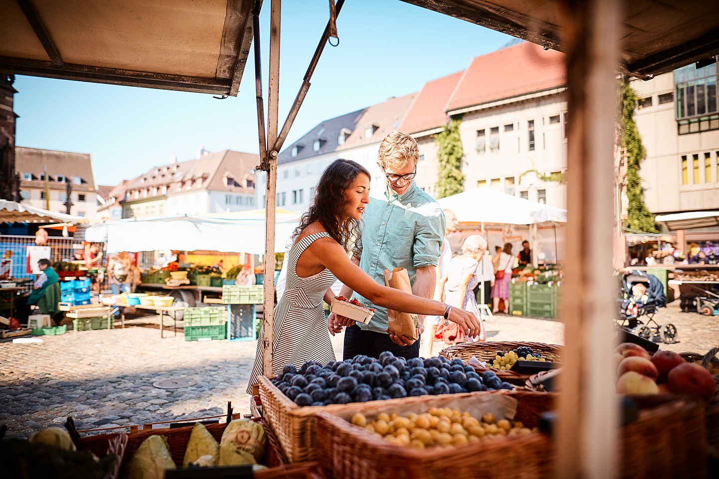 Eine Frau kauft auf dem Wochenmarkt ein.
