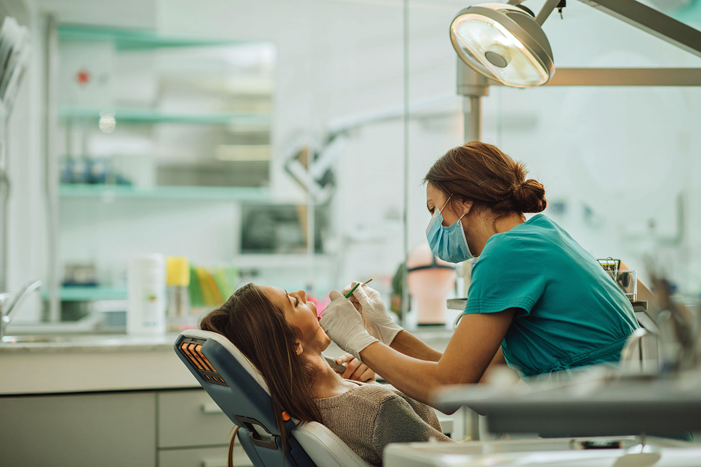 Eine Frau ist beim Zahnarzt und lacht.