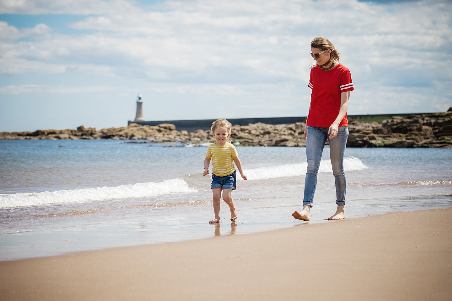 Eine Mutter und Kind sind am Strand an der Nordsee und spazieren.
