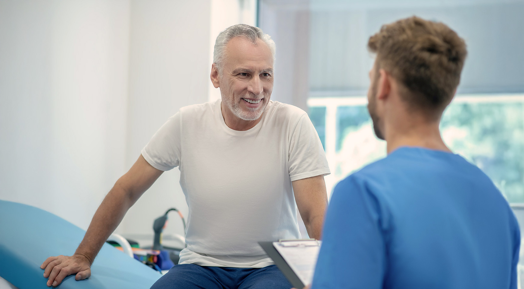 Ein Mann ist beim Arzt und spricht über seine Gesundheit bei einem Gesundheits-Check-Up.