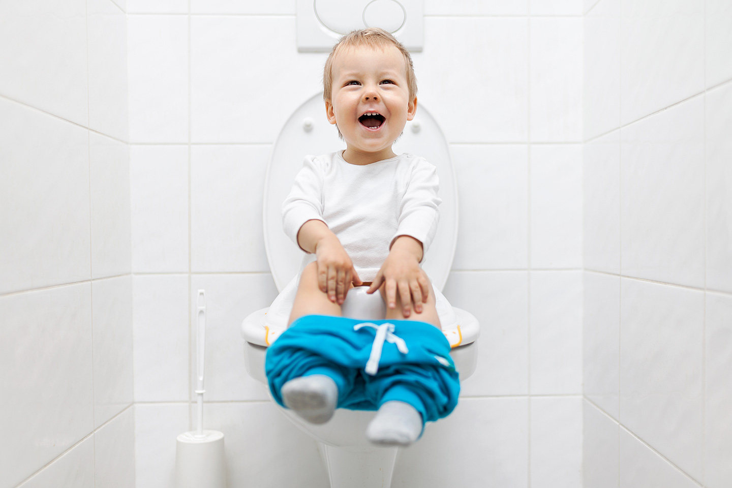 Ein fröhliches Kleinkind sitzt auf der Toilette.