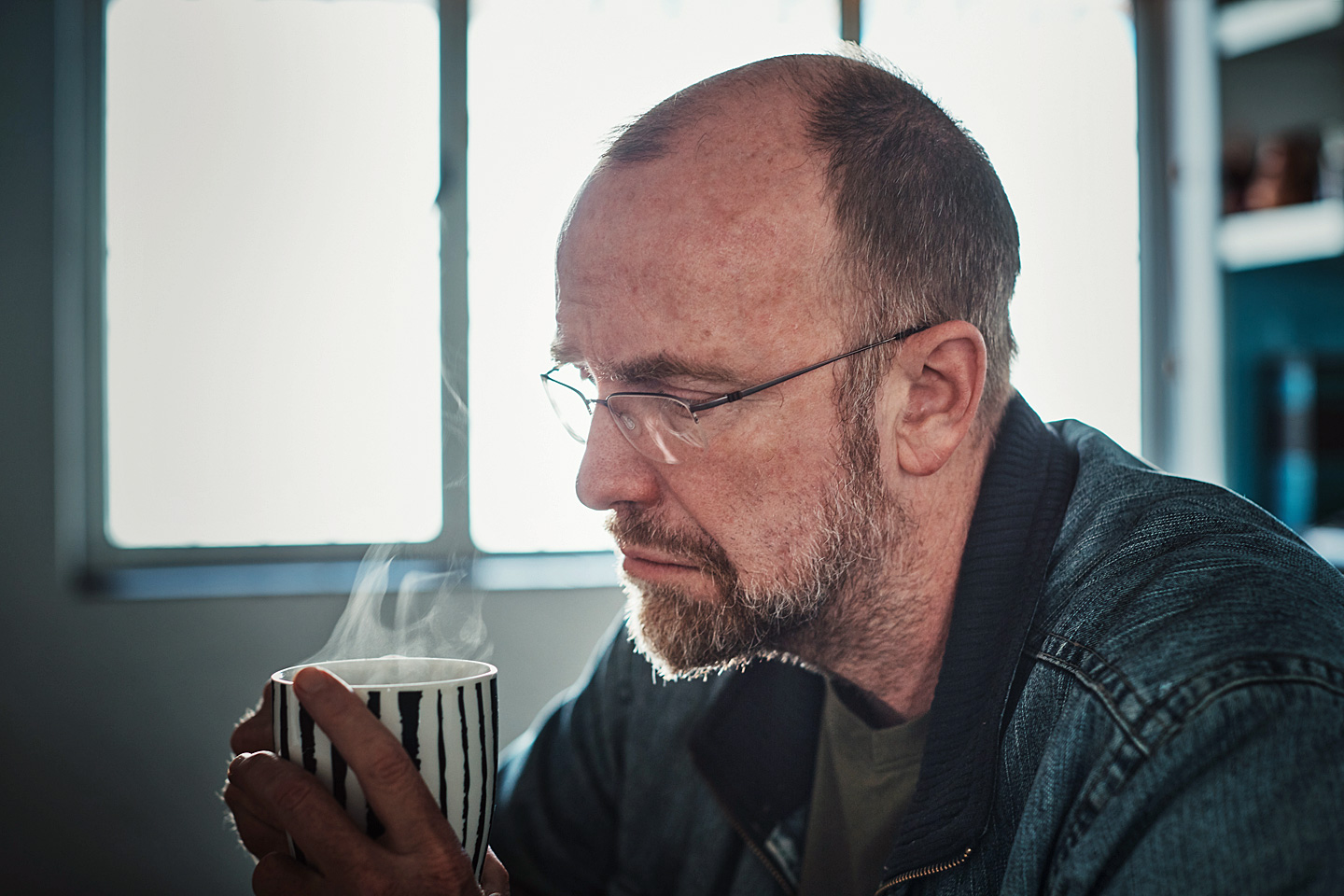 Ein Mann um die 50 mit Midlife-Crisis trinkt resigniert einen Kaffee.