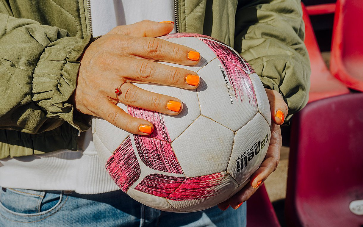 Okka Gundel hält einen Fußball in der Hand