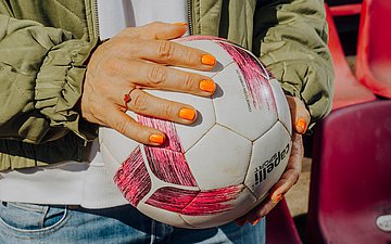 Okka Gundel hält einen Fußball in der Hand