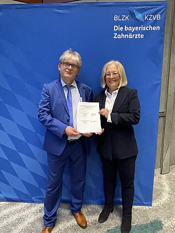 Foto zeigt Dr. R&uuml;diger Schott, Vorsitzender des Vorstands der KZVB, und Dr. Irmgard Stippler, Vorstandsvorsitzende der AOK Bayern, die einen Vertrag unterzeichneten, der die zahnmedizinische Versorgung von Pflegebed&uuml;rftigen mit schwerwiegenden k&ouml;rperlichen oder geistigen Behinderungen verbessert. 