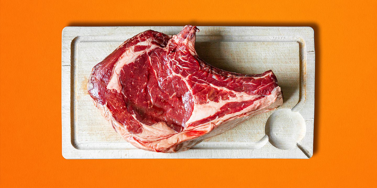 Symbolbild eines rohen Steaks auf einem Holzbrett