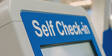 An einem Automaten steht "Self Check-in".