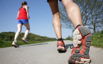 Joggen Foto: Zwei Joggende von hinten unten aufgenommen, vom rechten sind nur die Beine und eine Schuhsohle zu sehen.