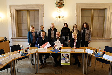 Gruppenfoto mit im Bild von links sitzend: J&uuml;rgen Spickenreuther (Direktor der AOK Nordoberpfalz), Andreas Meier (Landrat des Landkreises Neustadt an der Waldnaab NEW), Dr. Melanie Bayerlein (stv. Abteilungsleiterin Gesundheitsamt NEW). Im Bild von links stehend: aus dem Fachbereich "Strategie und Vertr&auml;ge, Versorgungsmanagement der AOK Bayern" Evelyn Martius (Teamleiterin) mit Martina P&ouml;ppel (Referentin) und Bettina Laux (Fachbereichsleiterin) sowie als Projektverantwortliche im Landkreis NEW Daniela Peintinger (Gesundheitsamt), Emilia Stauner (Landratsamt) und Barbara M&auml;dl (Landratsamt)