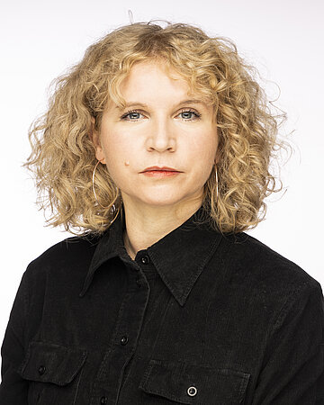 Das Portr&auml;t zeigt Dr. Andrea Kimmel. Sie hat blonde schulterlange Haare und tr&auml;gt ein dunkles Hemd.