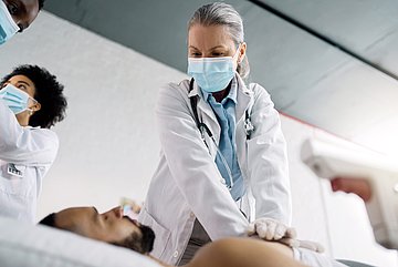 Herz-Kreislauferkrankungen Foto: Eine Ärztin macht eine Herzdruckmassage bei einem Patienten.