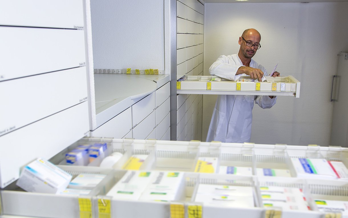 Apotheker hinter offenen Schubladen