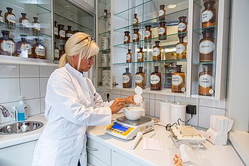 Eine Apothekerin stellt ein Arzneimittel her.