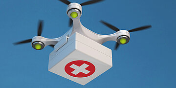 Eine Drohne f&uuml;r den medizinischen Einsatz fliegt am blauen Himmel.