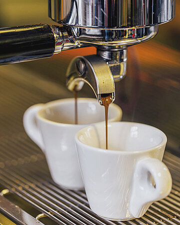 Eine automatische Kaffeemaschine bei der Zubereitung von Espresso.