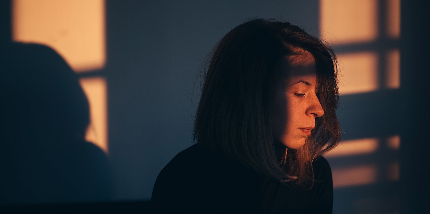 Foto: Gesicht einer Frau im Schatten.