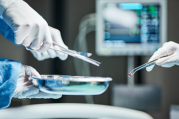 Das Foto zeigt eine Detailansicht von Pinzette und Schere w&auml;hrend einer Operation.