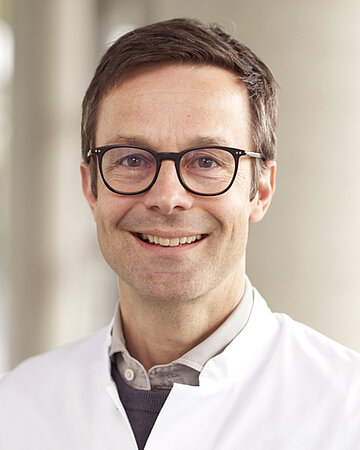 Portr&auml;t von Prof. Dr. Michael Denkinger, bei dem er freundlich in die Kamera l&auml;chelt