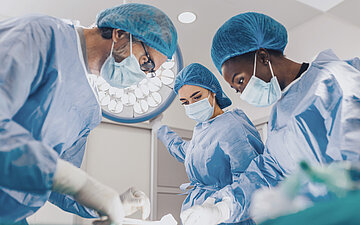 &Auml;rztinnen und &Auml;rzte f&uuml;hren eine Operation durch.