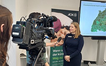Gesundheitsreport 2024 AOK-Geschäftsführerin Marion Rostam von der Bezirksdirektion Neckar-Alb wird von einem Kamerateam interviewt.