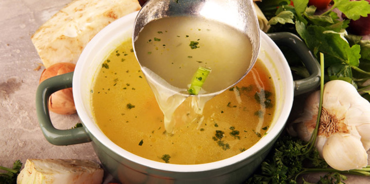 Das Foto zeigt einen Teller mit klarer Suppe.