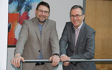 Andreas Schneider und Bernhard Ibach stehen nebeneinander und schauen in die Kamera.