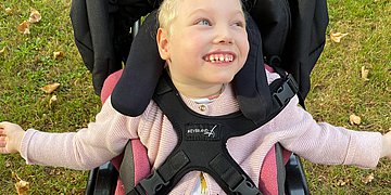 Lissenzephalie Foto eines kleinen,blonden Mädchens, das in einem Buggy sitzt