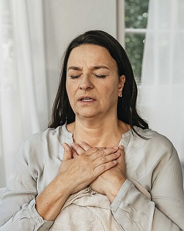 Eine Frau ringt mit Atemproblemen.