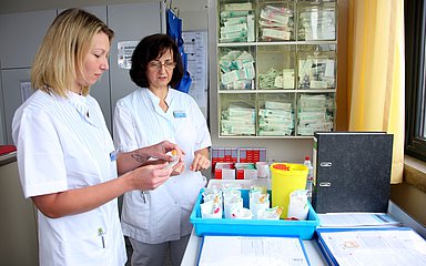 Zwei Pflegerinnen tauschen sich aus.