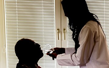 Ein &auml;lterer Patient wird von einer Pflegekraft versorgt.