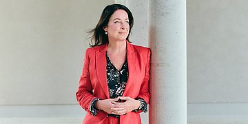 Foto: Britta Müller, Ministerin für Gesundheit und Soziales des Landes Brandenburg, an eine Säule gelehnt.