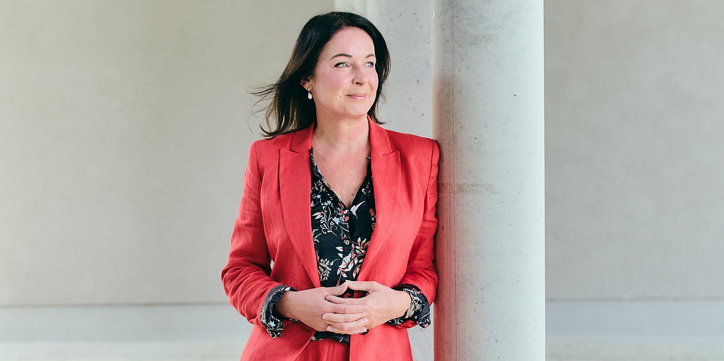 Foto: Britta Müller, Ministerin für Gesundheit und Soziales des Landes Brandenburg, an eine Säule gelehnt.