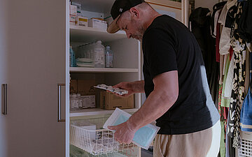 Foto: Markus Riepl holt verschiedene Hilfsmittel aus dem Schrank.