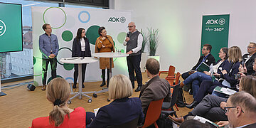 Interessierte h&ouml;ren der Diskussion beim Pflegeforum der AOK Bayern zu.