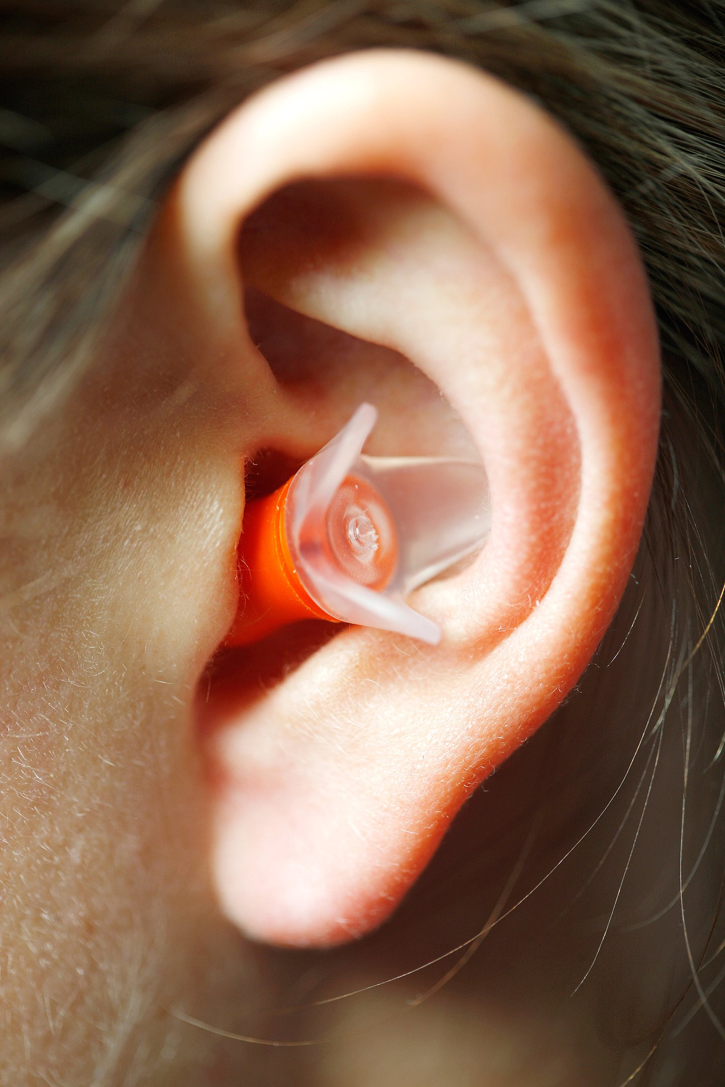 Foto: Eine Person trägt einen Ohrstöpsel.