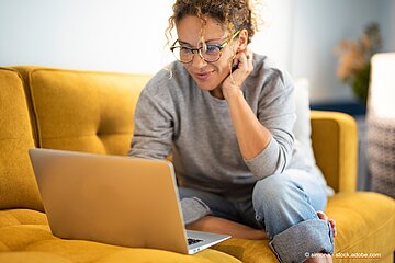 Frau sitzt vor dem Laptop