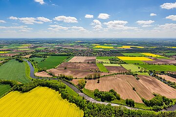 Foto: Vogelperspektive &uuml;ber Felder und Wiesen, am Himmel Wolken 