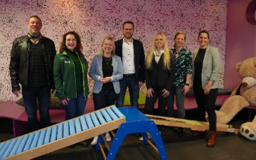 Gruppenbild Politikerinnen und Mitarbeiter in Kita vor Sportger&auml;ten 