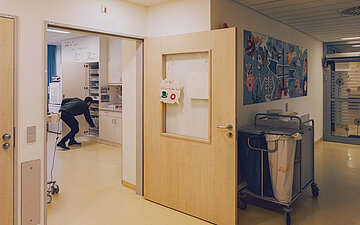 Foto von Pfleger Khaled, wie er einen Schrank mit Medikamenten und medizinischen Utensilien best&uuml;ckt