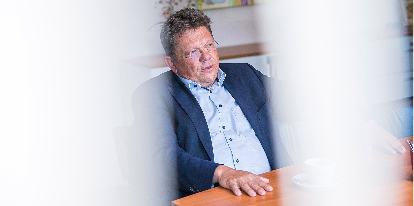Foto von Andreas Philippi im Gespräch an einem Holztisch