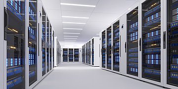 Das Foto zeigt einen Serverraum, rechts, links, sowie an der Stirnseite stehen Serverschränke.