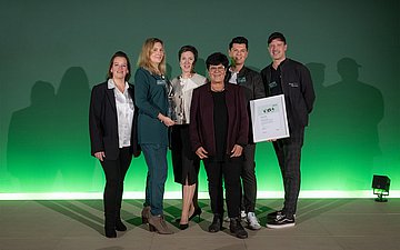 Foto: 6 Personen stehen nebeneinander, eine hält eine Urkunde.