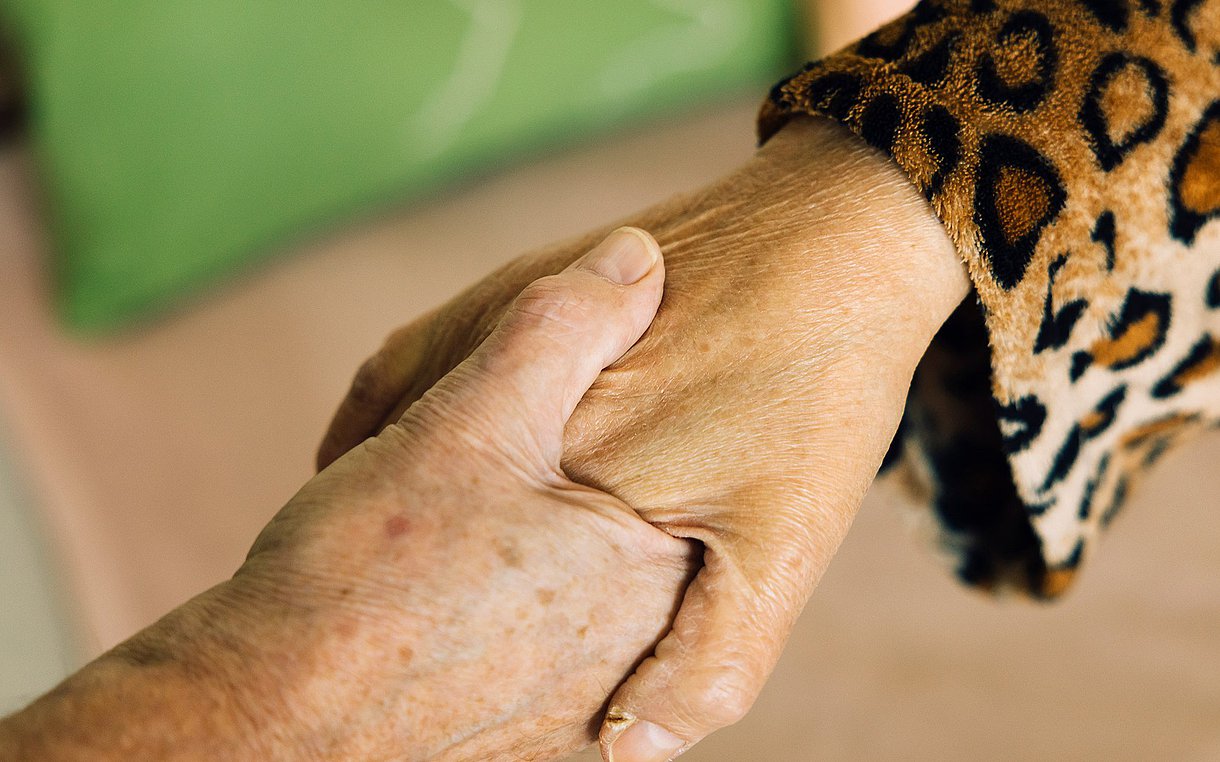 Foto einer Hand, die eine andere Hand hält