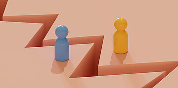 Zwei Spielfiguren, eine hellblau, die anderen gelb stehen auf einem hellorangenen Untergrund. Dieser ist in der Mitte zwischen den beiden Spielfiguren zackenf&ouml;rmig gerissen.