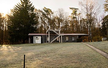 Blick auf das unscheibare Holzhaus, in dem sich die Messzentrale für Luftqualität am Stechlinsee befindet