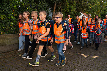 Grundschulkinder mit Warnwesten auf dem Schulweg.