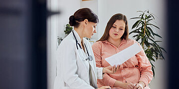 Eine &uuml;bergewichtige junge Frau spricht mit einer &Auml;rztin.