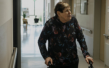 Foto: Patientin mit Rollator auf dem Klinikflur.