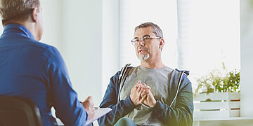 Ein Arzt f&uuml;hrt ein vertrauliches Gespr&auml;ch mit einem Patienten.