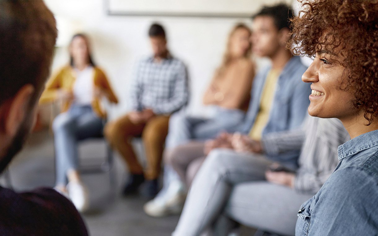 Foto eines Sitzkreises mit Menschen verschiedener Herkunft